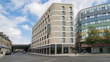Een modern hotel met een gebogen gevel, meerdere verdiepingen en een opvallende entree.