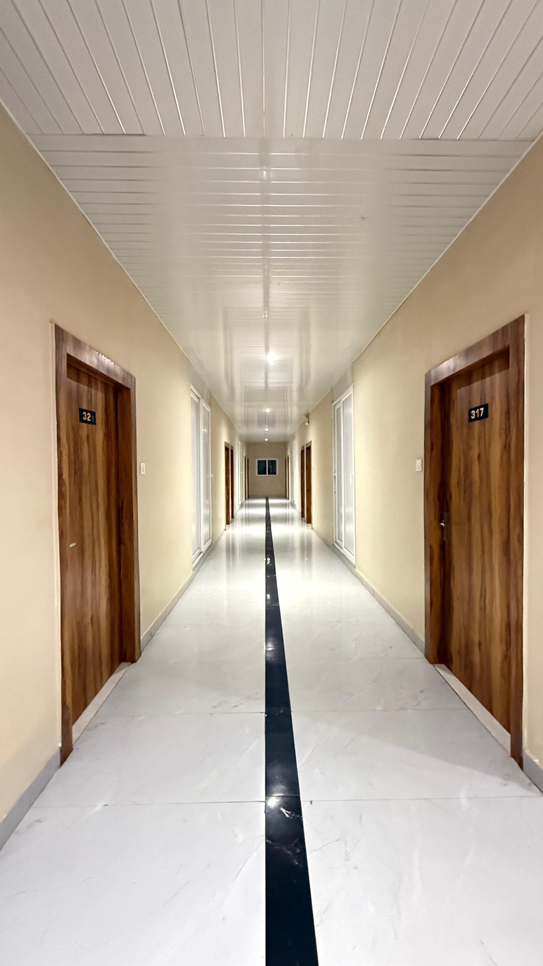A long, narrow hallway with doors on both sides, numbered 321 and 317, leading to rooms.
