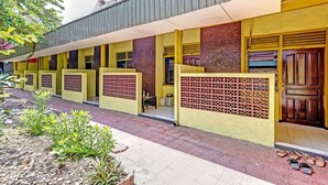 Un edificio con fachada amarilla, varias puertas y un pórtico.