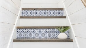 A staircase with white walls and blue patterned tiles.