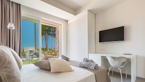 Une chambre d’hôtel moderne équipée d’un lit, d’un bureau et d’une télévision.