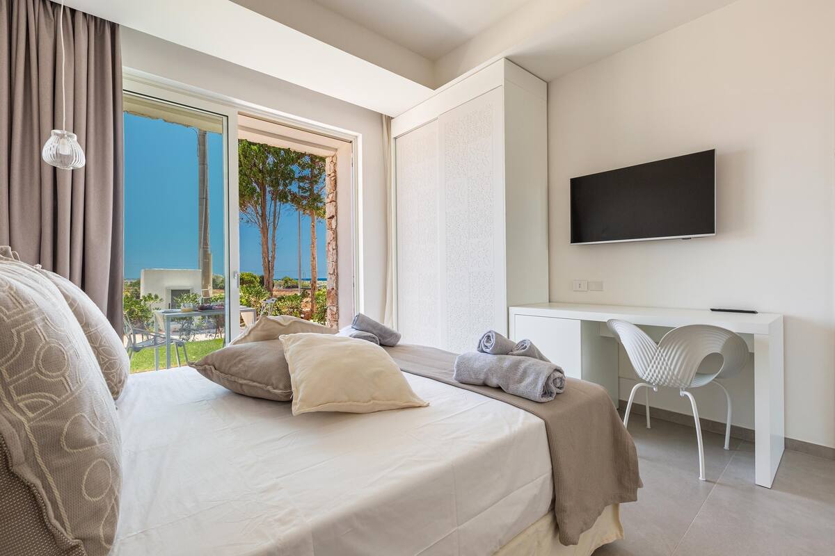 Una habitación de hotel moderna con una cama, un escritorio y un televisor.