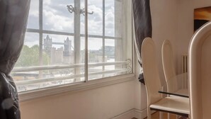 A room with a large window, a chair, and a radiator. - Large & Central 2BD Flat - Tower Hill (London)