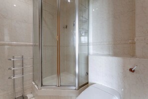A modern bathroom with a glass-enclosed shower, a toilet, and a towel rack. - Large & Central 2BD Flat - Tower Hill (London)