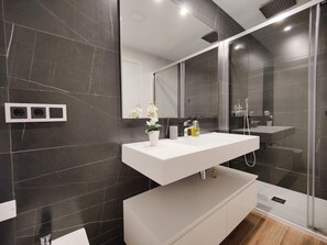 A modern bathroom with a white vanity, a large mirror, and a glass-enclosed shower. - SUNSET WAVES apARTs by RB (Benidorm)