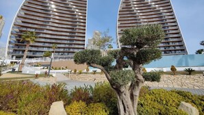 A modern building with a curved facade and balconies. - SUNSET WAVES blue sky apartment (Benidorm)