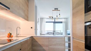 Una cocina moderna con armarios de madera, un lavamanos de acero inoxidable y un horno empotrado.