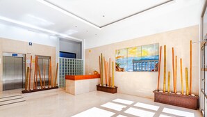 A modern lobby with an elevator, a reception desk, and a painting of a coastal scene. - BALCÓN DEL MAR sunny apartment (Benidorm)