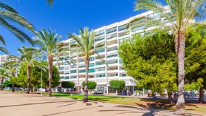A multi-story hotel with balconies, palm trees, and a clear blue sky. - BALCÓN DEL MAR sunny apartment (Benidorm)