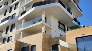Ein mehrgeschossiges Wohngebäude mit Balkonen, großen Fenstern und modernem architektonischen Design.