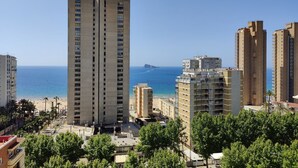 A high-rise building with multiple floors, a beach in the background, and surrounding residential buildings. - GERONA sea view apartments (Benidorm)