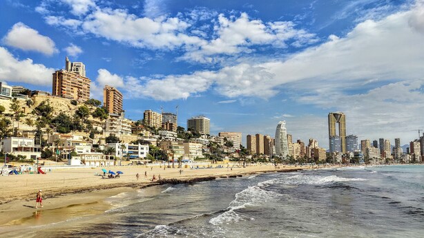 A coastal cityscape with a beach, high-rise buildings, and a clear sky. - MIRADOR beach apartments (Benidorm)