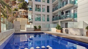 A modern hotel with a swimming pool, balconies, and a view of the surrounding buildings. - MIRADOR beach apartments (Benidorm)