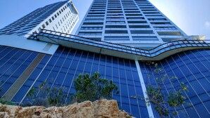 Un immeuble moderne de grande hauteur, doté d’une façade incurvée originale et de grandes fenêtres.