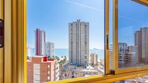 Un edifici alt amb vista despejada al mar i altres edificis al fons.