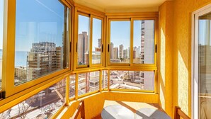 Habitació d'angle amb grans finestres i vista a la ciutat.