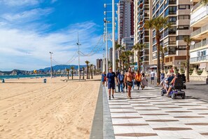A beachside promenade with a checkered pavement, palm trees, and high-rise buildings in the background. - GERONA sea view apartments (Benidorm)