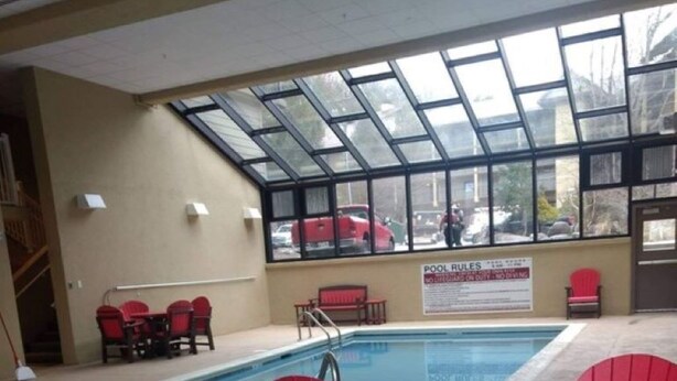 An indoor pool area with a glass ceiling, red Adirondack chairs, and a pool table. - 3BR/2BA Stand-alone condo. Close to downtown (Gatlinburg)