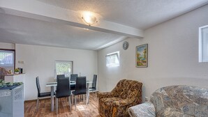 A room with a dining table, chairs, a patterned armchair, a sofa, a clock, and a window. - 2 BR House By The Creek Near Plitvice Lakes (Plitvicka Jezera)
