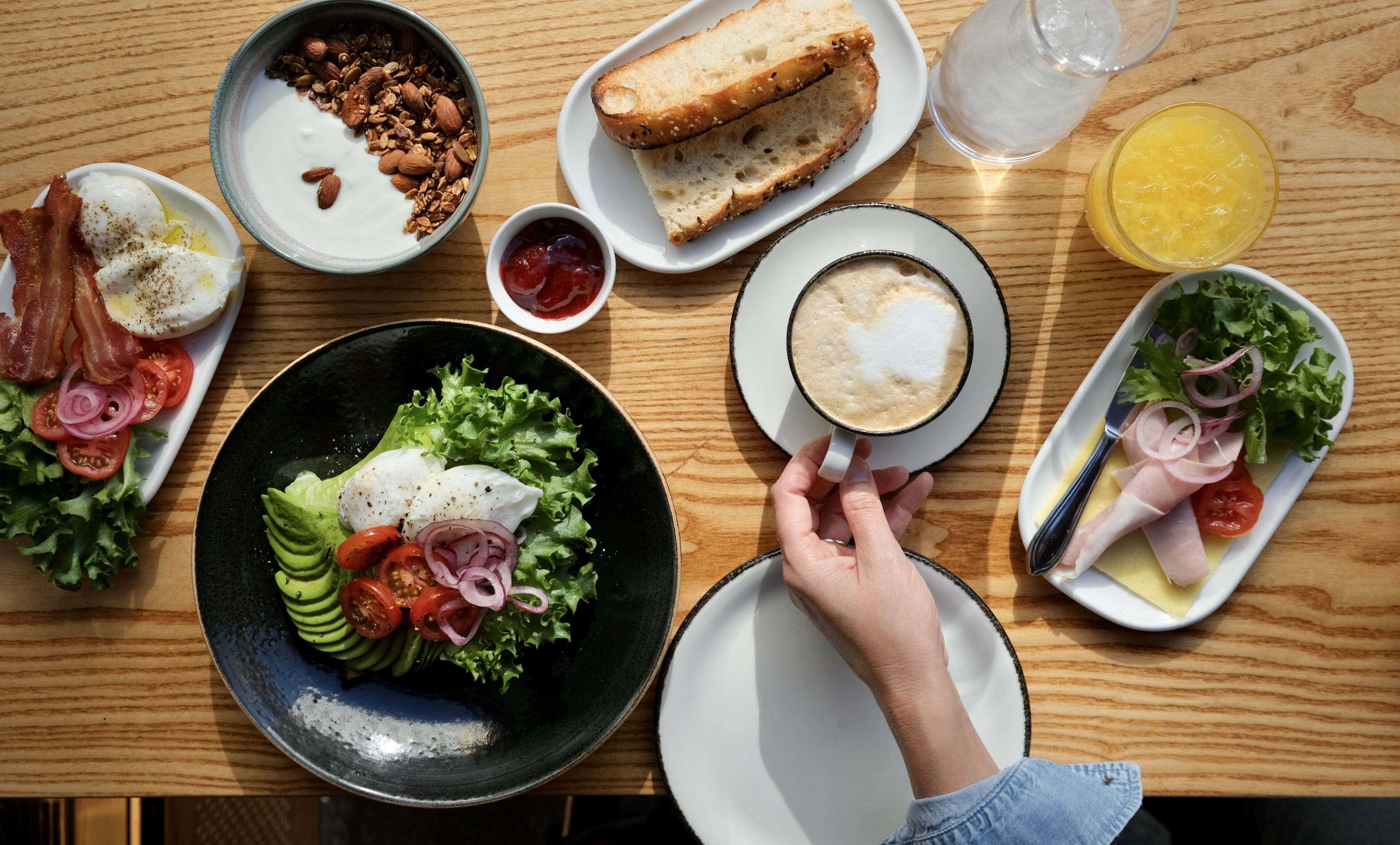 Un desayuno con diferentes platos, como huevos, tostadas y una ensalada.