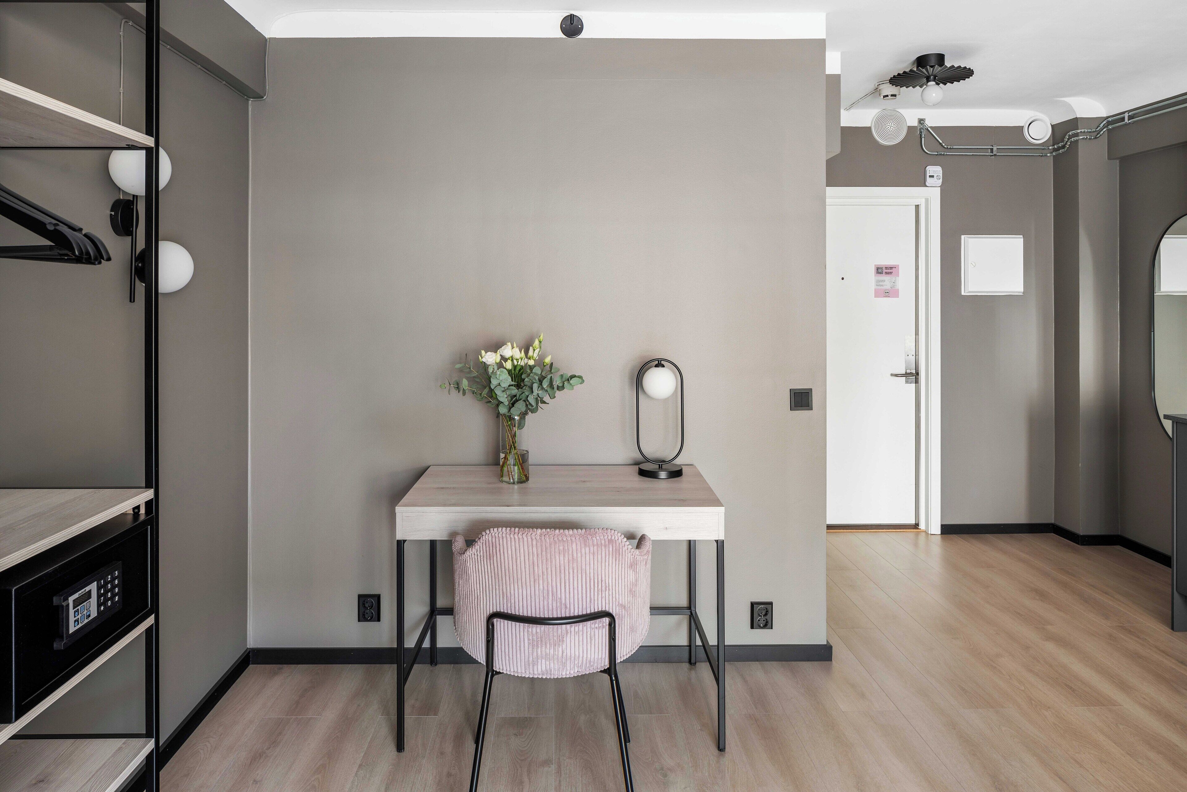 Une chambre moderne équipée d’un bureau, d’une chaise et d’un miroir.