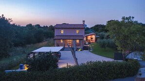 A two-story house with a tiled roof, a driveway leading to the entrance, and a small garden area. - Villa Azur – Private pool, wellness, and spacious garden (Muntic)