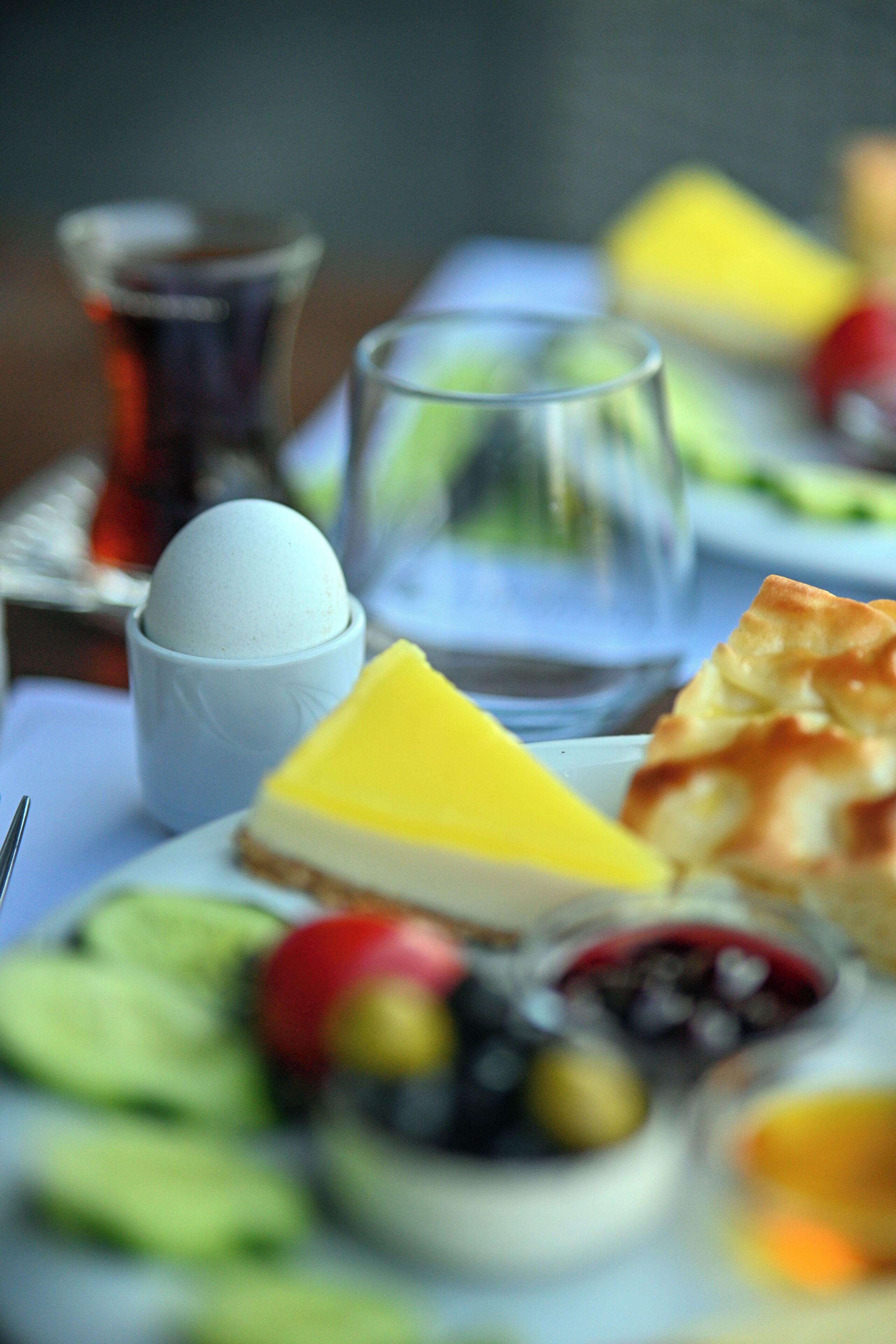 A meal with various dishes including a cheese slice, a small bowl, and a glass of water.