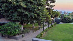 A landscaped garden with a paved walkway, mature trees, and a well-maintained lawn. - Denizati Plus Hotel (Istanbul)