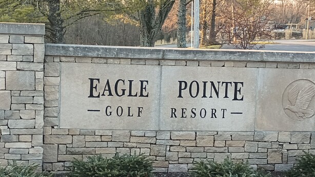 Eine Steinsäule mit dem Schriftzug "Eagle Pointe Golf Resort" und einem Taubenwappen.