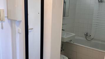 Un baño con inodoro, lavamanos y bañera.