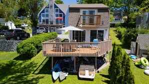 A two-story house with a deck, a garage, and a swimming pool. - Waterfront Cottage at Highland Lake w/dock (Winsted)