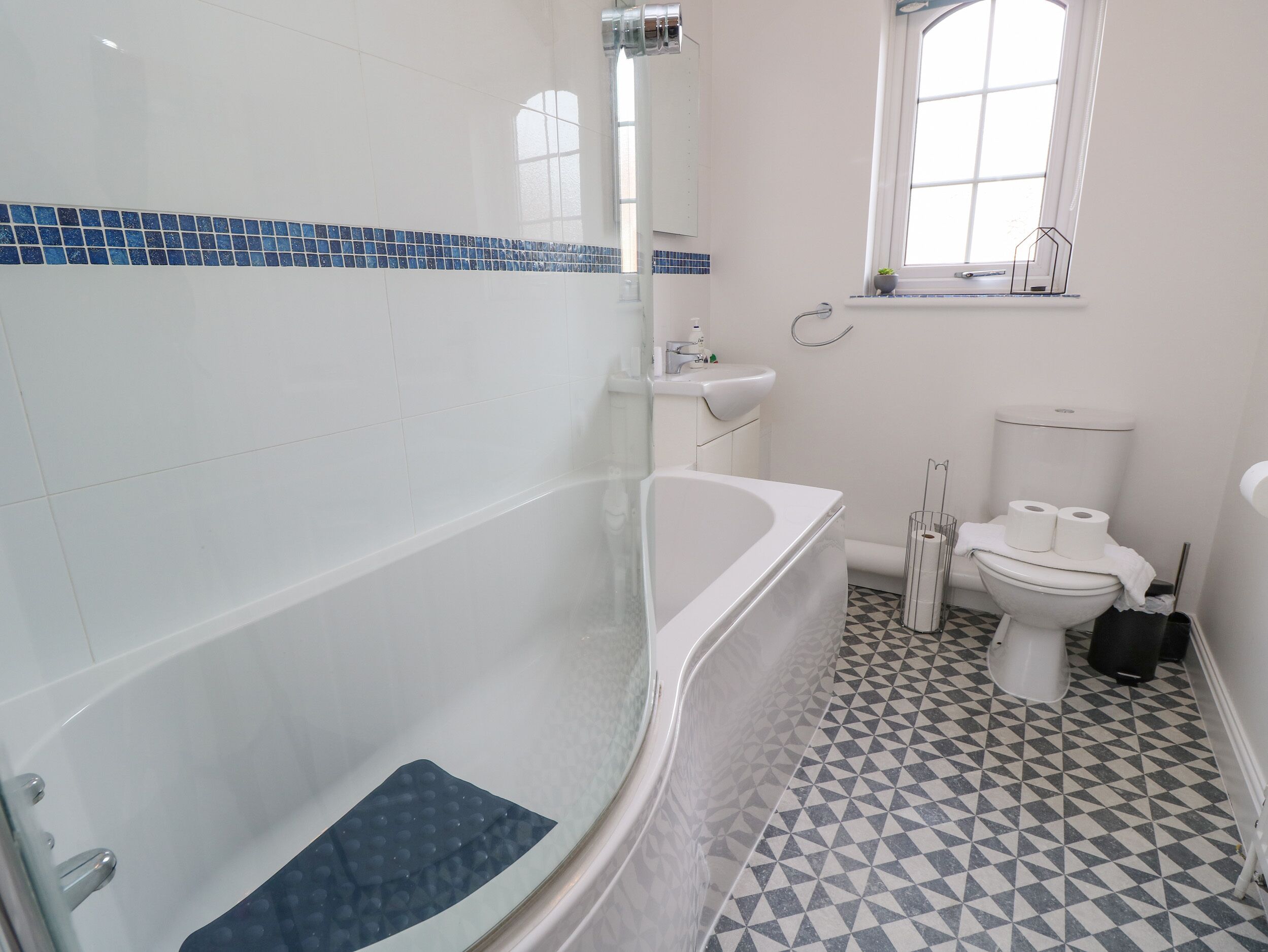 A bathroom with a bathtub, toilet, and sink.