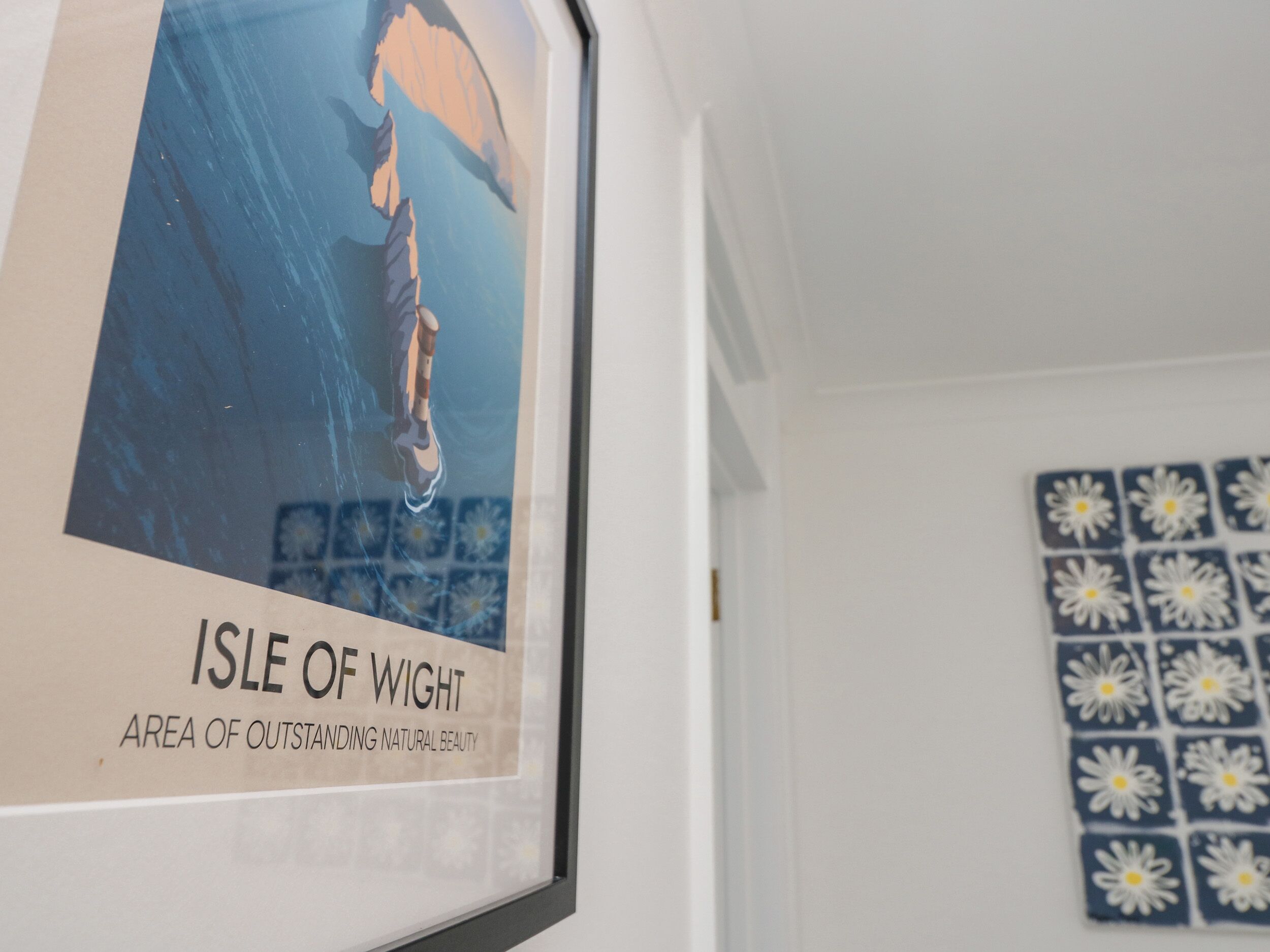 A framed poster of a person swimming in water with the text 'ISLE OF WIGHT AREA OF OUTSTANDING NATURAL BEAUTY.'