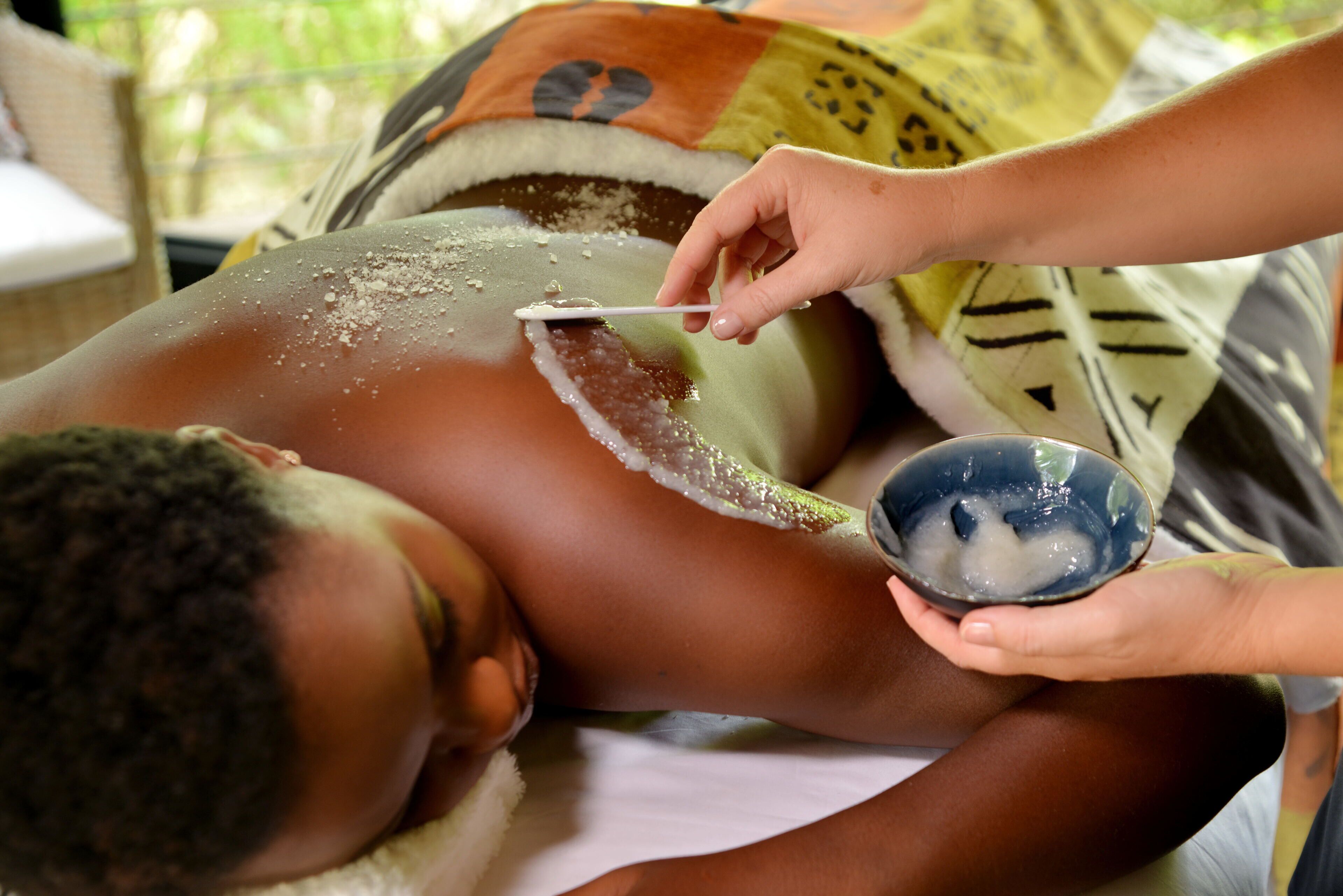 A person receiving a treatment with a bowl of ice and a spoon.