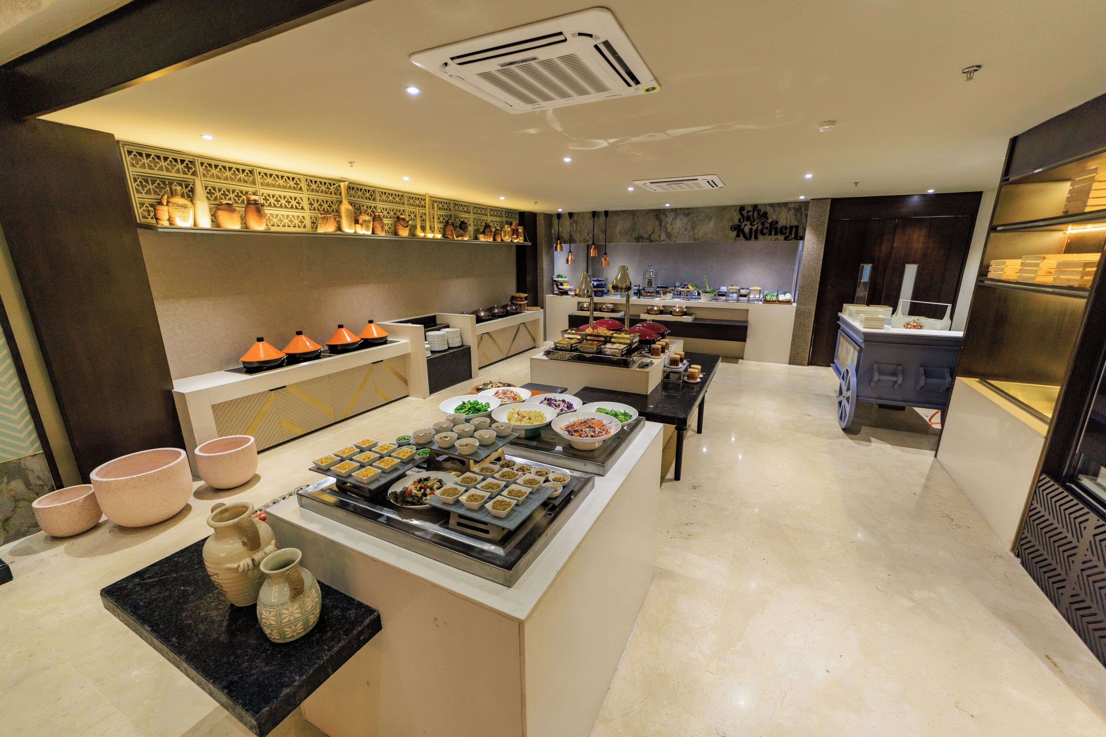 A modern kitchen with a buffet setup, featuring various food items and decorative elements.
