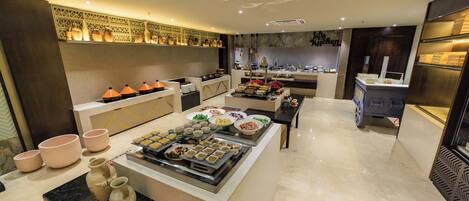 A modern kitchen with a buffet setup, featuring various food items and decorative elements.