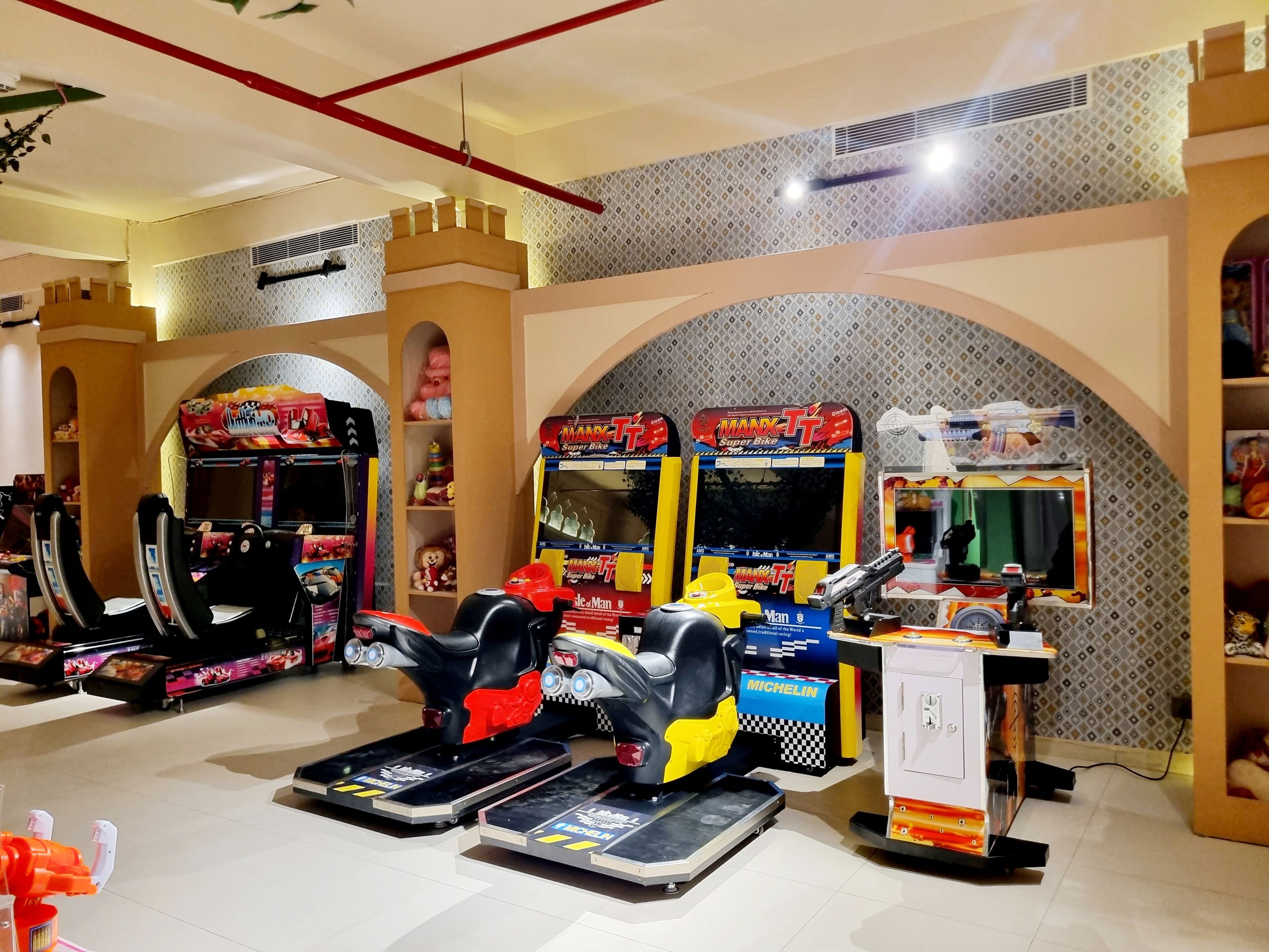 Una sala de juegos con diversos juegos de carreras y motos, incluyendo Manx TT Super Bike.