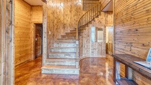A wooden interior with a staircase, polished floors, and a bench. - Tatanka @ Frio Premier Rental Homes (Concan)