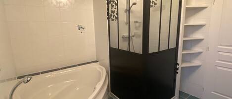 A bathroom with a bathtub, a shower enclosure, and a toilet.