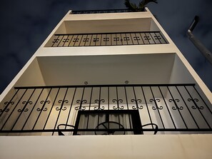 A building with a white facade and black metal railings. - One Lodge (Pattaya)