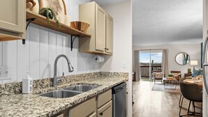 A kitchen with granite countertops, a dishwasher, and a built-in oven. There is a dining area with a table and chairs, and a view of the outdoors through a sliding glass door. - 3BR Ozark View Condo | Near Branson Strip (Branson)