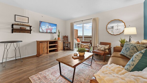 A living room with a sofa, coffee table, and a view of a balcony. - 3BR Ozark View Condo | Near Branson Strip (Branson)