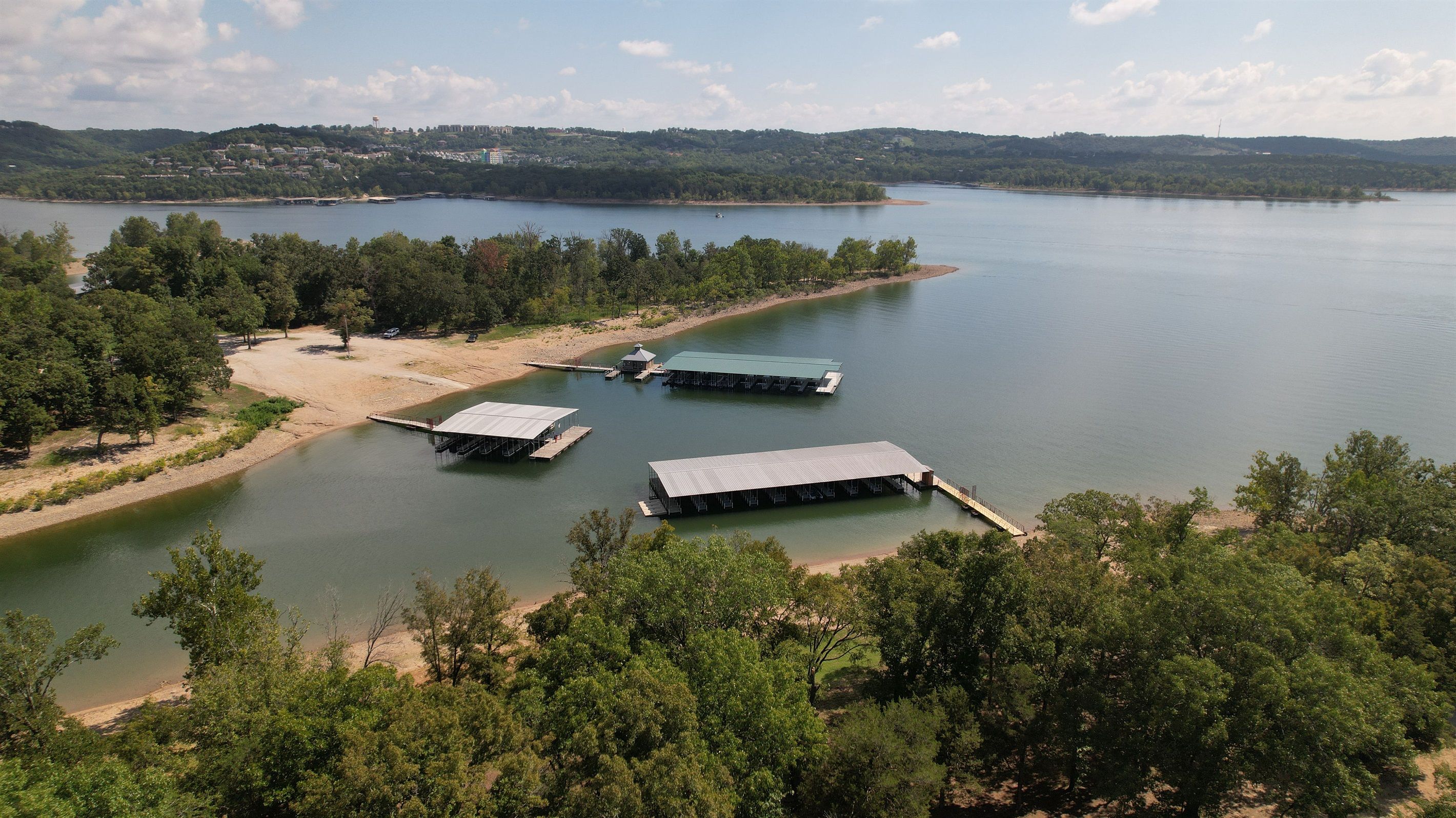 A lakeside property with multiple docks and a sandy beach area.