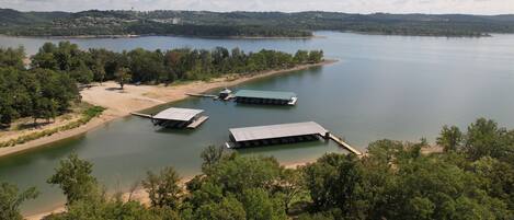 A lakeside property with multiple docks and a sandy beach area.