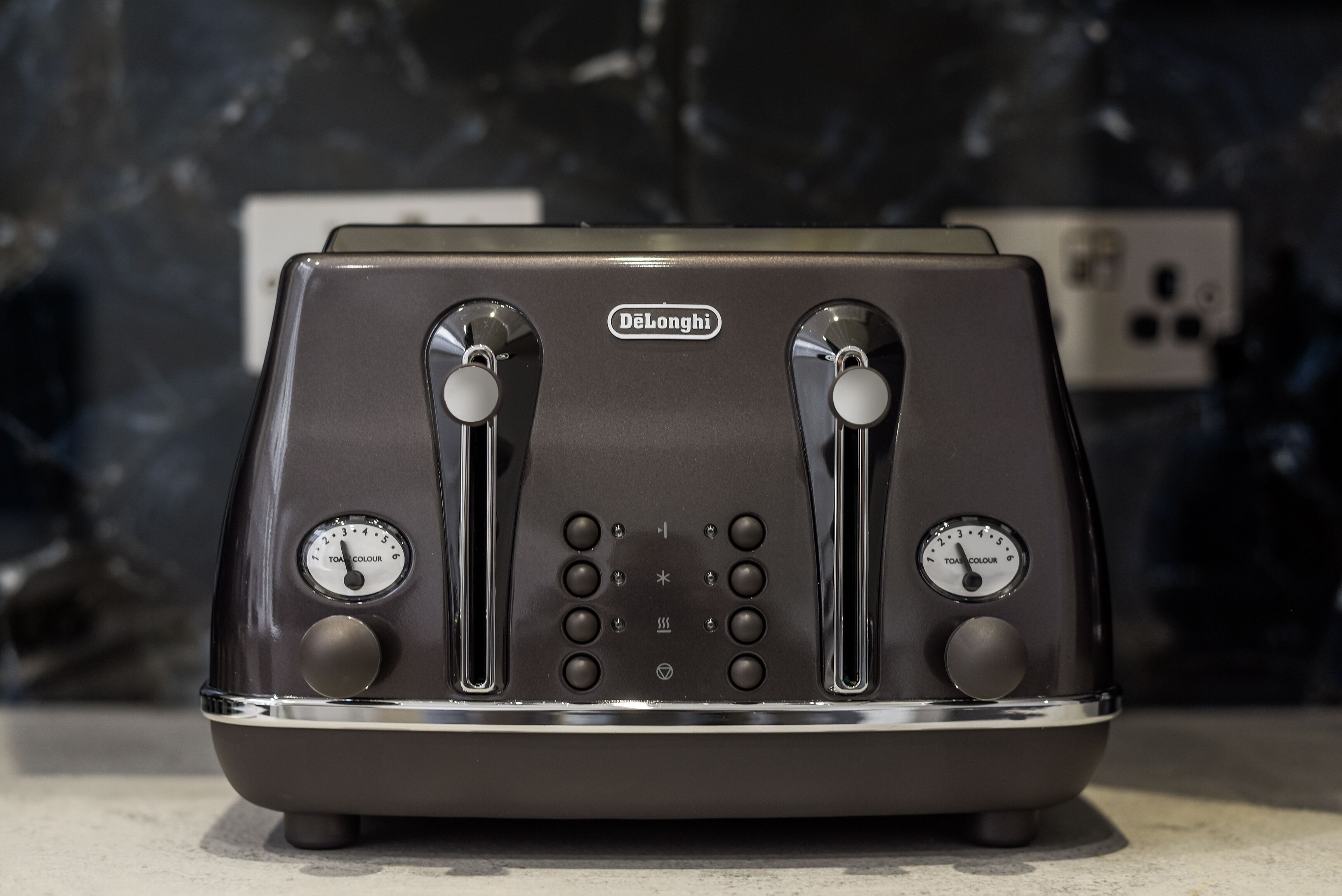 Un grille-pain DeLonghi à deux fentes, doté d’un bouton de réglage et d’un panneau de commande.