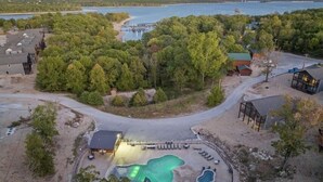 Un resort con una amplia piscina, una zona techada y vistas a un lago.