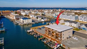 A waterfront hotel with multiple decks, a dock area, and a view of the sea. - Newport Bay 5 by Seaside Vacations & Sales (Ocean City)