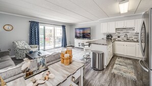 A modern kitchen with white cabinets, a stainless steel refrigerator, and a built-in oven.