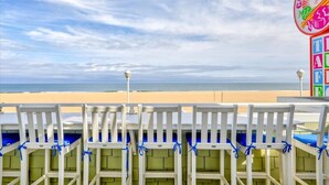 Une vue sur la plage, avec des chaises blanches et un panneau indiquant l'emplacement de « Candy Kitchen ».