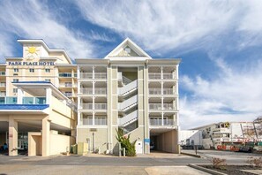 A multi-story hotel with a central atrium, balconies, and a parking area. - Somerset on 2nd 202 by Seaside Vacations & Sales (Ocean City)